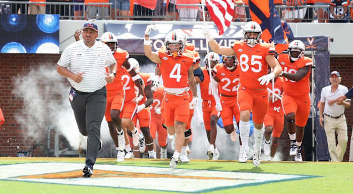 Tony Elliott, Billy Kemp, and Grant Misch lead the Virginia Cavaliers onto the field at Scott Stadium ahead of UVA's season opener against Richmond.